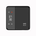 Sterilizator UV periuțe dinți NIRU ProUV negru, compact, cu display LED digital. Imaginea prezintă dispozitivul închis, evidențiind ceasul, pictogramele UVC și uscare, și logo-ul UVC BOX.